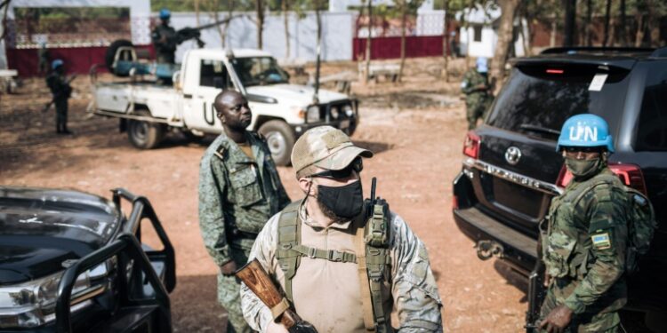 A Rwandan peacekeeper from Minusca (right), a Russian member of a private security group (center) and a member of the Central African presidential guard (left) on 27 December 2020 in Bangui | AFP