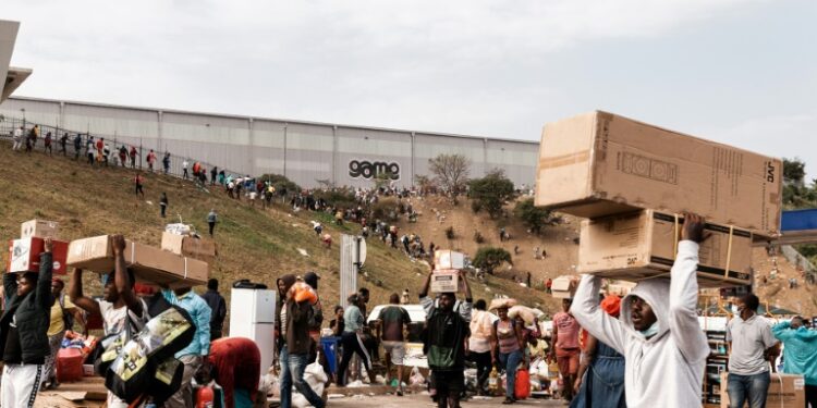 Suspected looters haul away goods from the Game Warehouse in Durban | AFP