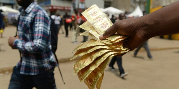 A healthcare worker distributes condoms in Kenya's capital Nairobi. Around 1.1 million condoms donated to the country have disappeared from a government warehouse | AFP