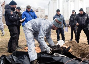 A forensic worker exhumes several bodies from a grave in Bucha, Ukraine, on April 12, 2022 | Anastasia Vlasova/Getty Images