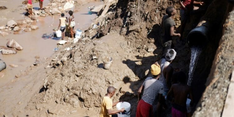 Residents collect clean water from a broken pipe in Amaoti, north of Durban | AFP