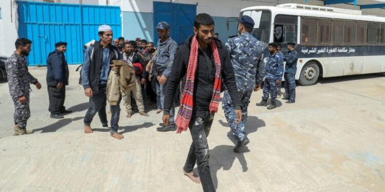 Members of the Libyan security forces accompany migrants into a reception centre near the capital Tripoli after their arrest while preparing an illegal and dangerous crossing to Europe | AFP