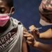 A boy receives a dose of the Pfizer/BioNTech vaccine against COVID-19 at Discovery vaccination site in Sandton, Johannesburg | AFP
