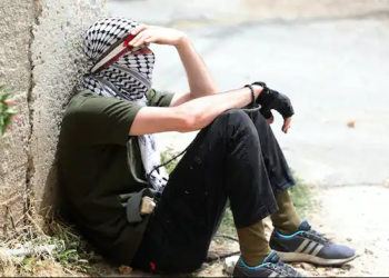A Palestinian protester rests during clashes with Israeli troops after a demonstration against Israel’s settlements, near Nablus, West Bank, June 9, 2023 | Alaa Badarneh/EPA