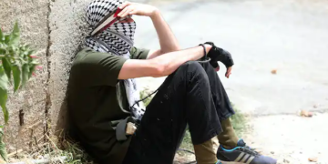 A Palestinian protester rests during clashes with Israeli troops after a demonstration against Israel’s settlements, near Nablus, West Bank, June 9, 2023 | Alaa Badarneh/EPA