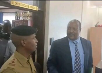 The besieged Rift Valley Water Works CEO Samuel Oruma engages a police delpoyed at the company's headquarters in Nakuru.