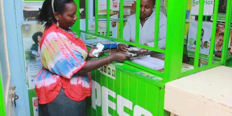 M-PESA agent attending to a customer.