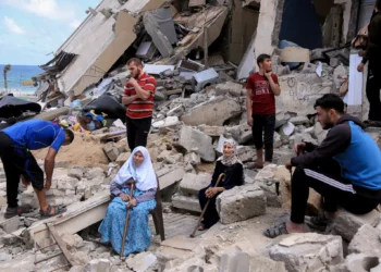 People sitting in the rubble of a bombed house in Gaza after a past attack. PHOTO/Samar Abu Elouf.