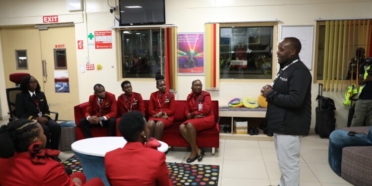 KQ CEO Allan Kilavuka (right) addresses a past meeting with the airline's staff. 