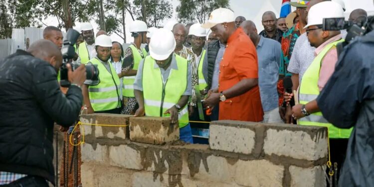 President William Ruto (in orange suit) presides over the launch of an affordable Housing proeject.