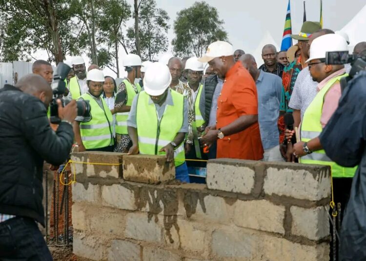 President William Ruto (in orange suit) presides over the launch of an affordable Housing proeject. 