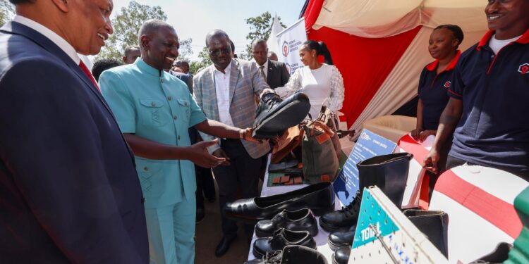 President William Ruto (second from left) interacts with traders during the celebrations of the first anniversary of the Hustler Fund.