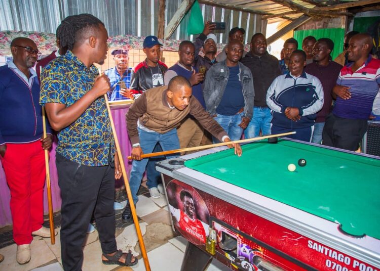 Embakasi East MP Babu Owino play pool with supporters in Utawala ward.