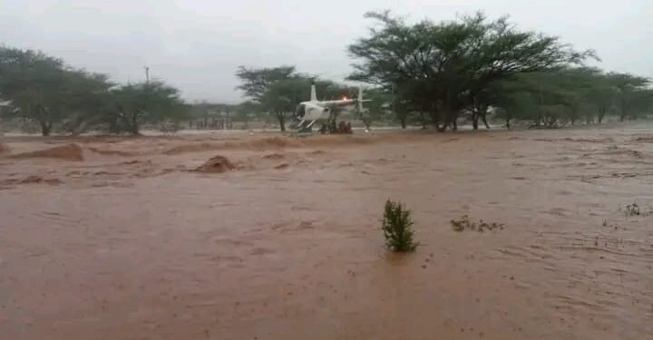 A helicopter flies above a flooded area on its way to evacuate stranded people in Samburu on November 3, 2023. 