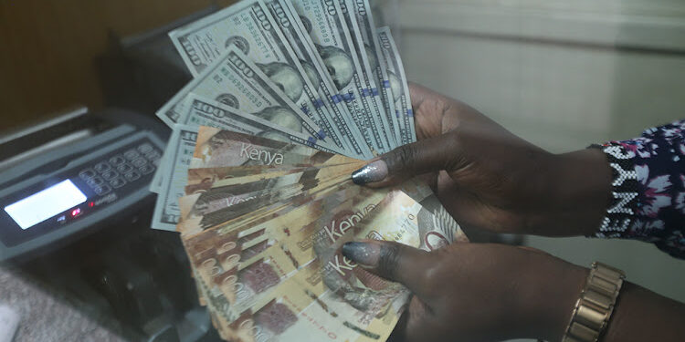 A cashier at a Nairobi forex bureau counts dollars and shilling notes. PHOTO/ Courtesy.
