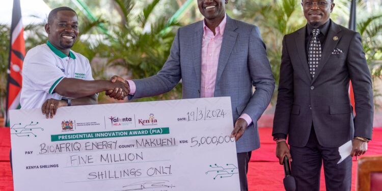 President William Ruto presents a cheque of Ksh3 million to Signvrse during the PIA at State House Nairobi.PHOTO/PCS.