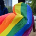 LGBTQ+ Activist walking in the streets with a pride flag. PHOTO/BBC