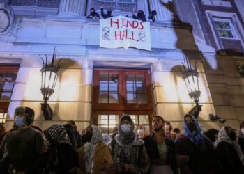 Protesters link arms outside Hamilton Hall barricading students inside the building at Columbia University. PHOTO/ Reuters