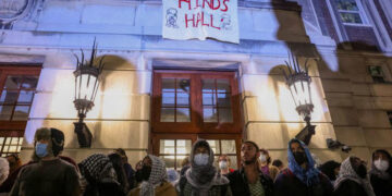 Protesters link arms outside Hamilton Hall barricading students inside the building at Columbia University. PHOTO/ Reuters