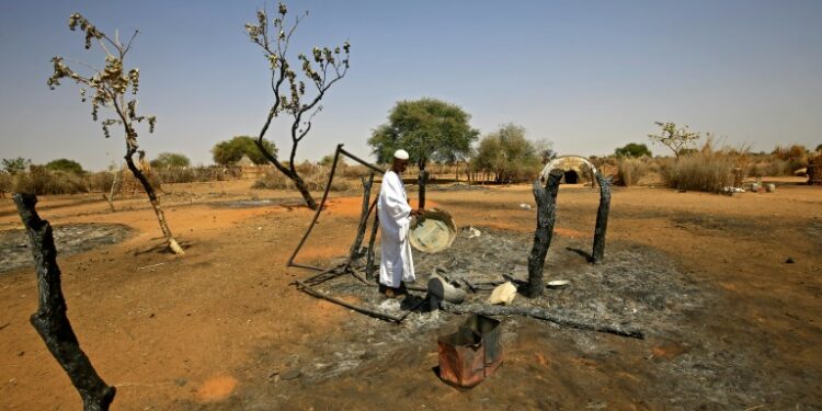 AFP | After years of conflict, clashes still erupt in the Darfur region; a man checks the aftermath of violence in the village of Twail Saadoun, the capital of South Darfur, in February 2021