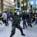 Tunisian demonstrators run for cover during clashes with police during a protest against President Kais Saied, on the 11th anniversary of the Tunisian revolution in the capital Tunis on January 14, 2022 | AFP