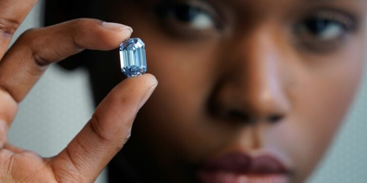 Model Stephany Martins holds up the "The De Beers Cullinan Blue" blue diamond during a press preview at Sotheby's in New York, on February 15, 2022 | AFP