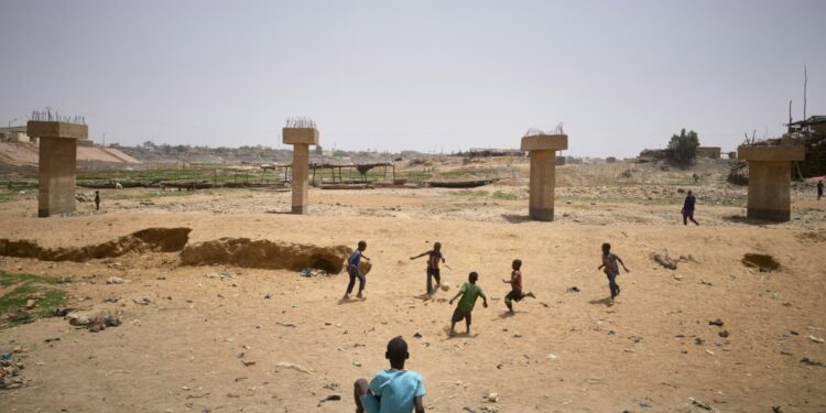 Children playing football in a dry arm of the inner delta of the Niger River, March 19, 2021 | AFP