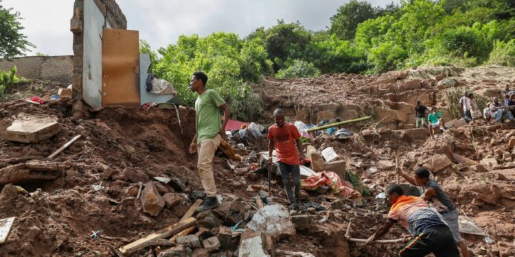 More than a dozen South African rescue workers on Friday painstakingly combed a lush green valley where 10 people from Hlophe's family have been missing for five days since violent floods tore through Durban city, killing 395 people | AFP