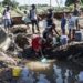 Residents in Durban's Inanda district collect water from a pool created by a collapsed road | AFP