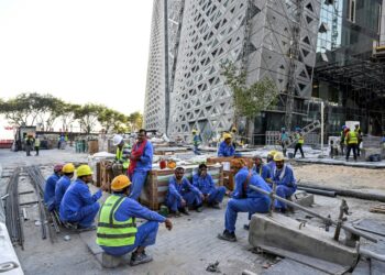 Migrant builders take a break while working at a construction site by the Corniche in Doha during the World Cup | AFP