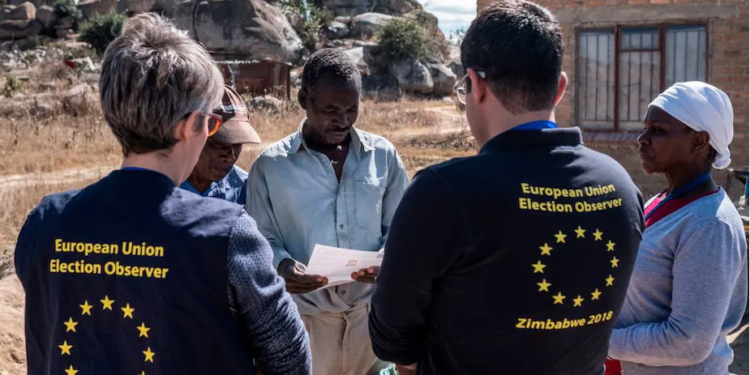 Members of a European Union election observation team speak to voters in Zimbabwe |  
 Marco Longari/AFP via Getty Images