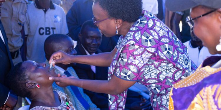 Minister of Health Dr Jane Ruth Aceng vaccinates a member of the community at the OCV launch (1). PHOTO/Courtesy