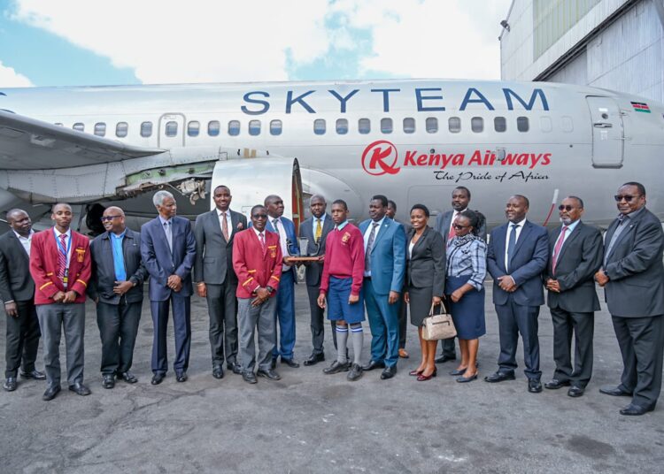 Transport CS Kipchumba Murkomen poses for a photo with Kenya Airways executives during the handing over of a Boeing 727-700 aircraft. 