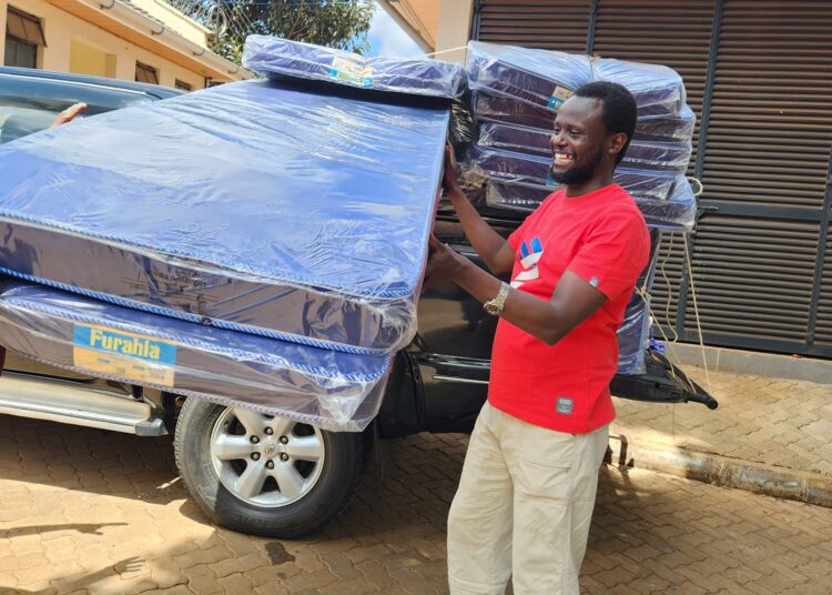 Meru Governor Kawira Mwangaza's spouse Murega Baichu poses for a photo with part of the mattresses meant for the okolea program. 