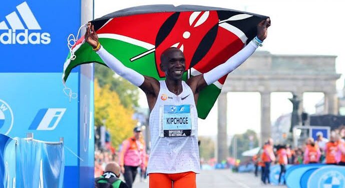Kenya's marathon runner Eliud Kipchoge waves Kenya's flag after his race in Berlin.