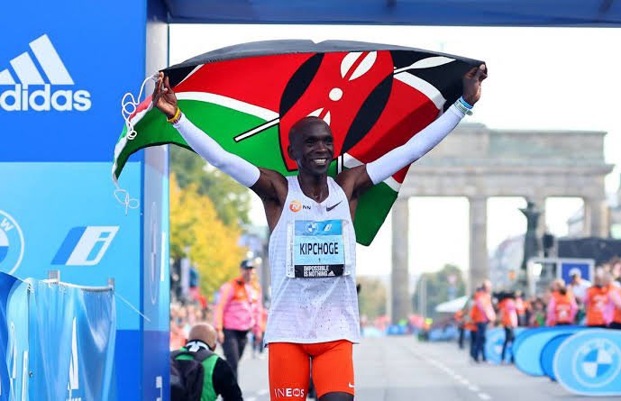 Kenya's marathon runner Eliud Kipchoge waves Kenya's flag after his race in Berlin. 