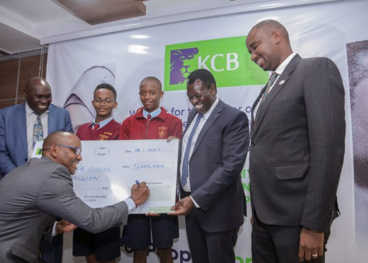 Kenya Commercial Bank's officials hands over a Ksh 5 million cheque to Mang'u High School to aid in equipping its aviation center in January 2023. 