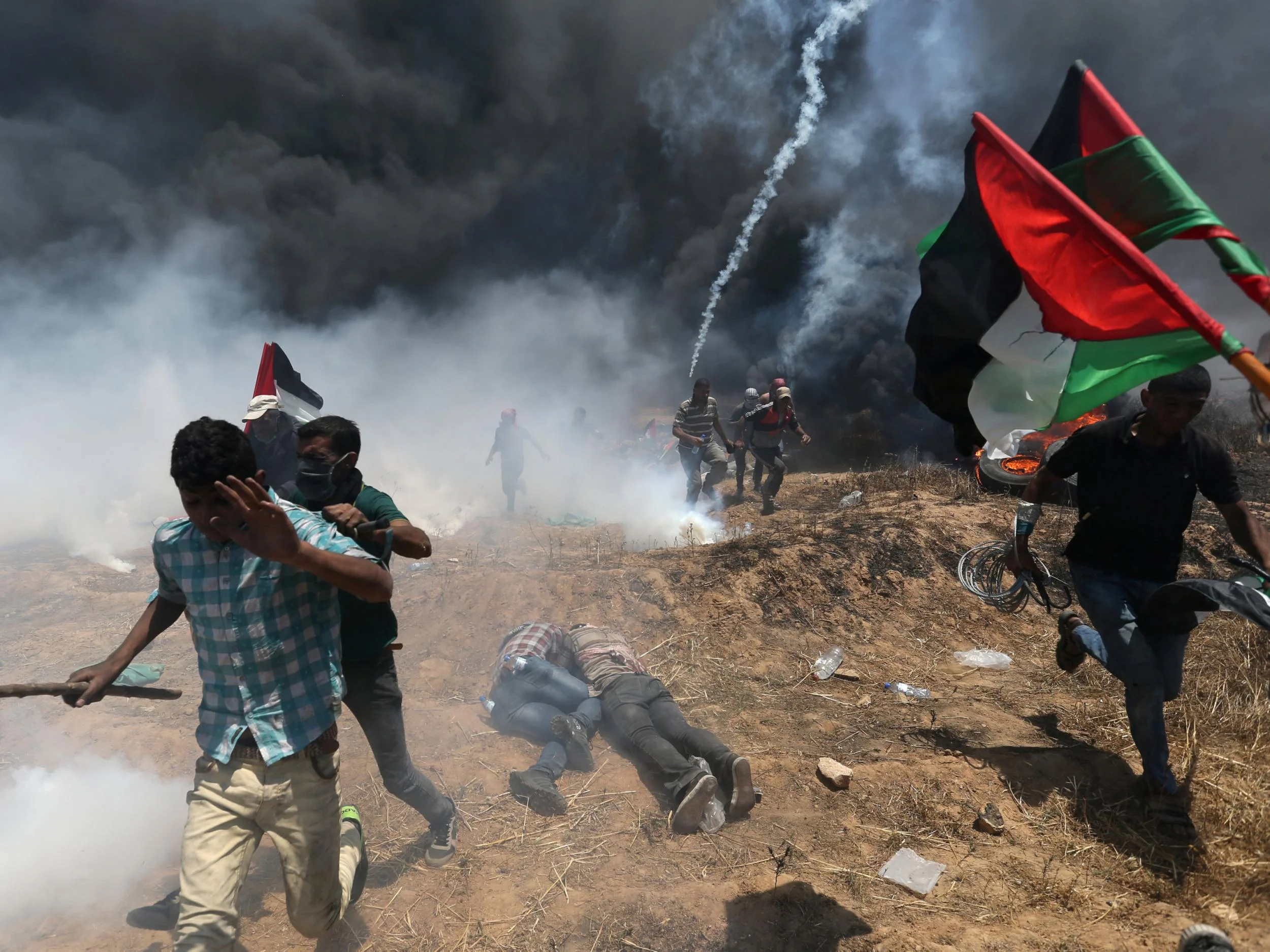 Palestine protesters flee from Israeli tear gas at a demonstration in May 2018. PHOTO/Reuters.