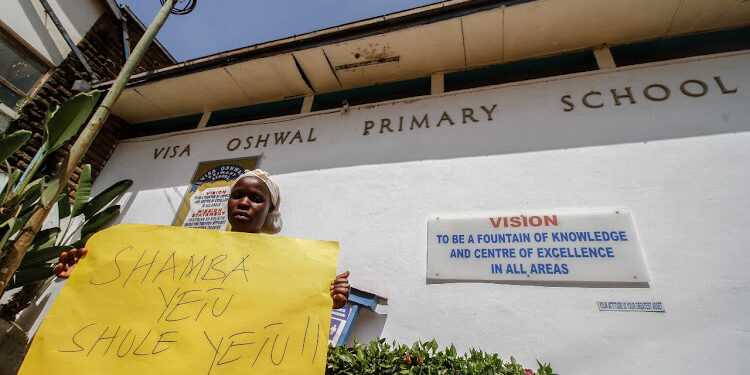 Staff at Oshwal Primary School holding a placard in 2022
