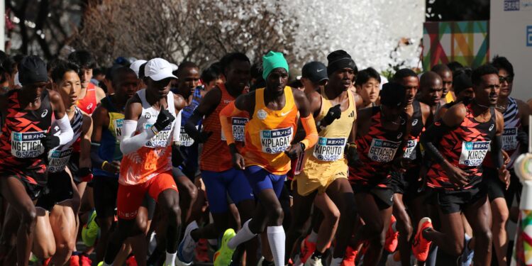 Men's elite runners including eventual winner Benson Kipruto (4th from right) and Eliud Kipchoge (white cap) set off at the start of the Tokyo marathon. PHOTO/ Courtesy