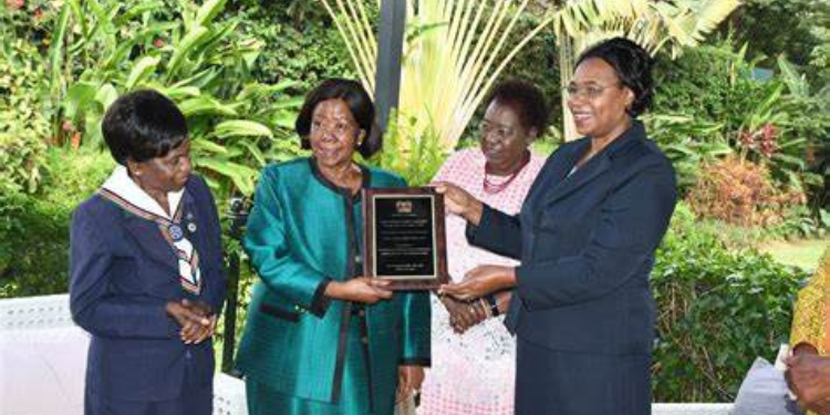 Former Cabinet Minister Nyiva Mwendwa receives an award from Gender CS Margaret Kobia as former Senator Zipporah Kittony looks on in Gigiri on February 25, 2022. PHOTO/ Courtesy